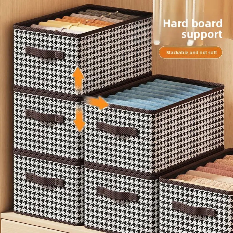 Six black-and-white houndstooth storage boxes with handles, stacked in a wooden shelf.