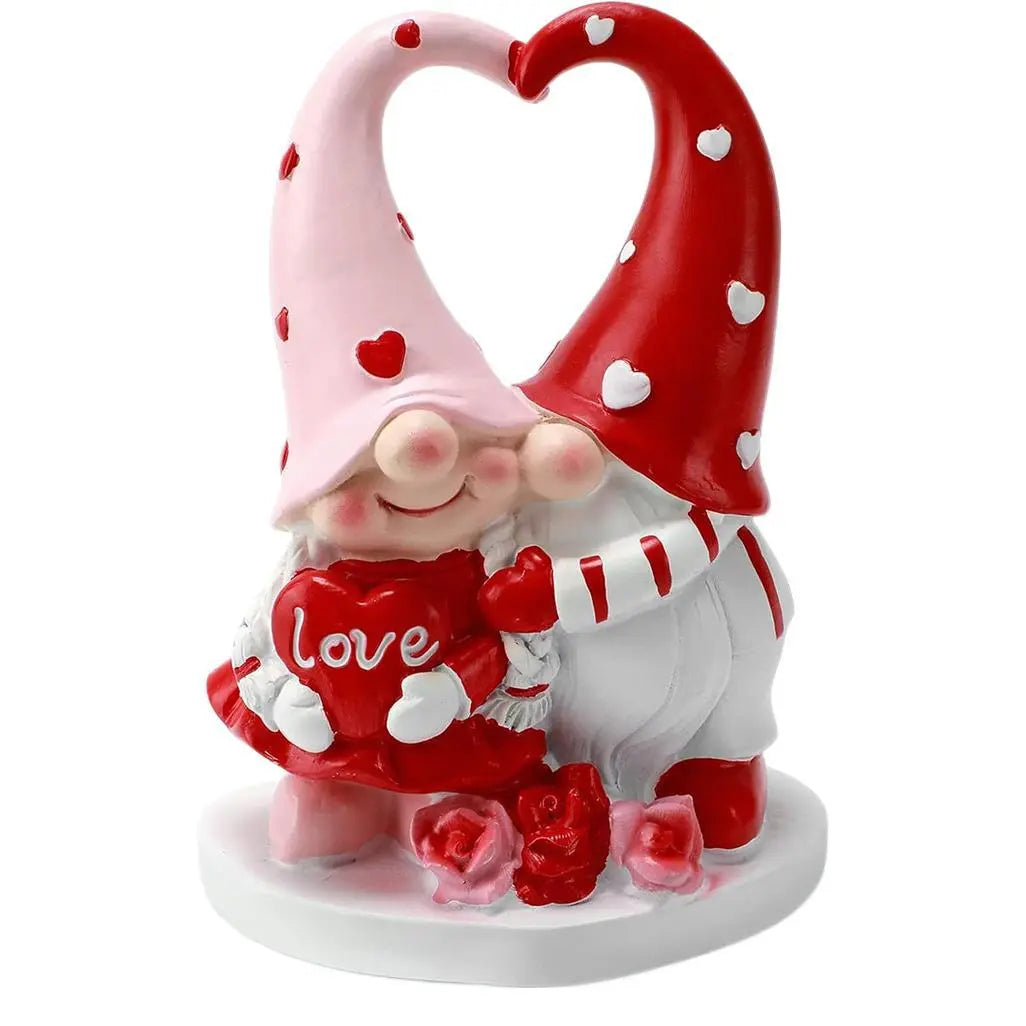 Two gnomes with heart hats hug, holding a red heart saying "love"; pink and red with white accents.